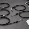 Generic aftermarket lawn mower control cables with blank fitment cards and measuring tools on a workbench