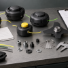 Generic aftermarket trimmer heads with thread gauges, measuring tools, and blank buyer checklists on a workbench